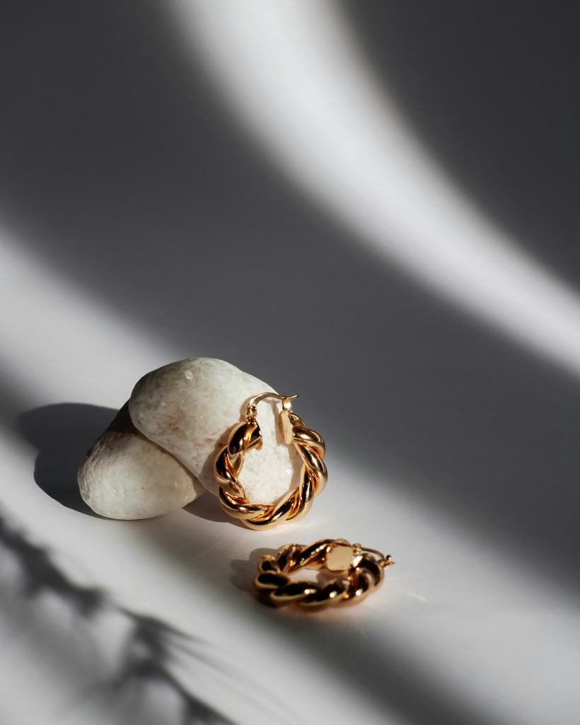 Aurelia gold-tone signet and band rings resting on grey silk
